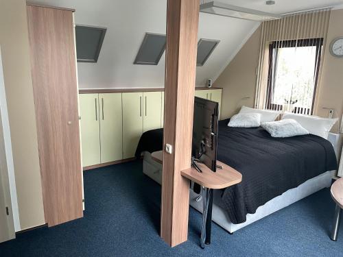 um quarto com uma cama e uma televisão em Ferienwohnung Geyer em Gräfenhainichen