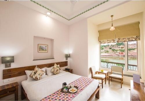 a bedroom with a bed and a table and chairs at Lakeside Inn Ratanada in Jodhpur