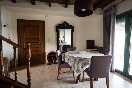 a dining room with a table and chairs and a mirror at Villa Pheia in Agios Andreas Ilias