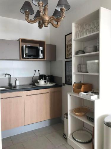 une cuisine avec un évier et un micro-ondes dans l'établissement Le Bleu Mer, à Sète