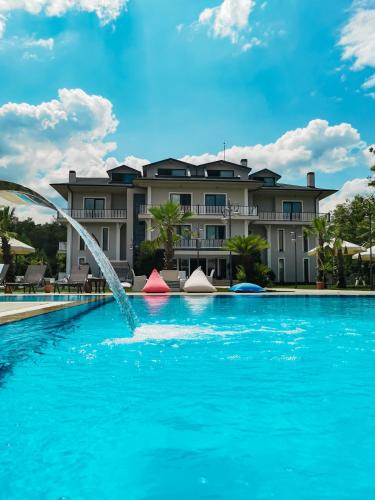 a pool with a fountain in front of a building at Didi Hotel Sapanca in Sapanca