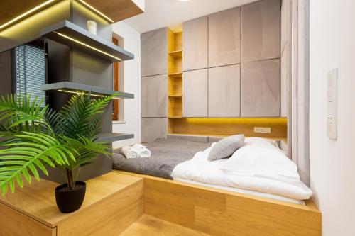 ein Schlafzimmer mit einem Bett und einer Topfpflanze in der Unterkunft Apartments City Center Grzybowska by Renters Prestige in Warschau