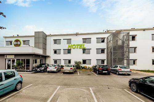 a hotel with cars parked in a parking lot at B&B HOTEL Bordeaux Le Haillan 3 étoiles in Le Haillan
