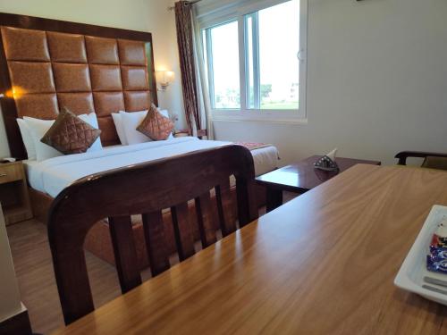 a hotel room with a bed and a table at Hotel Guru Surbhi in Pāonta Sāhib