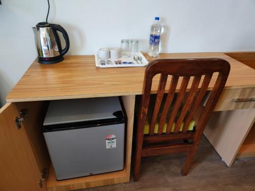 a wooden desk with a chair and a small refrigerator at Hotel Guru Surbhi in Pāonta Sāhib