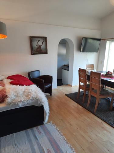 a living room with a bed and a dining room at Ferienwohnung Alpensonne in Oberstdorf