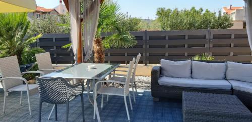 a patio with a table and chairs and a couch at Villa Dalmatina Zadar mit Pool in Zadar