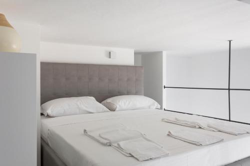 Una cama blanca con sábanas blancas y toallas. en Lofty loft - Chiese en Milán