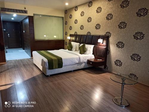 a hotel room with a bed and a projection screen at Hotel Patliputra Exotica in Patna