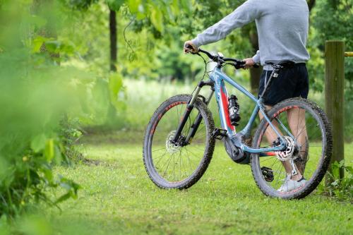 a man is holding a bike in the grass at Hotel Terme Delle Nazioni in Montegrotto Terme