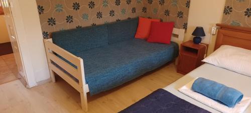 a small bedroom with a bed with a blue bedspread at Hungarian Farmhouse in Zákányszék