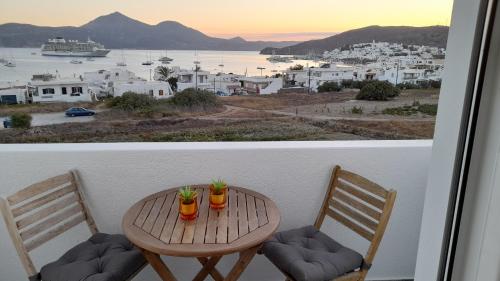 uma mesa e cadeiras numa varanda com vista para a cidade em Hotel Ippocampos Studios em Adamas