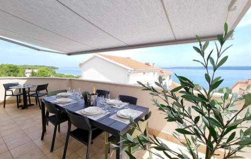 una mesa en un balcón con vistas al océano en Orkula Apartments en Pašman