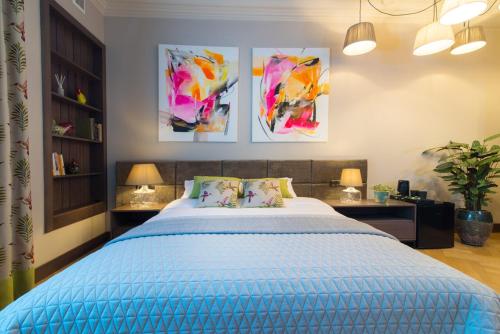 a bedroom with a bed and some paintings on the wall at Apartamenty u Sarzyńskich in Kazimierz Dolny