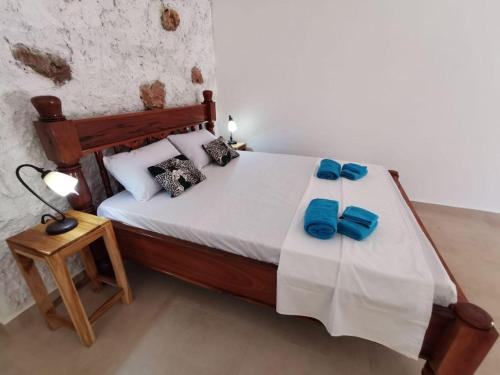 a bedroom with a bed with blue bows on it at Tamaru House Bungalow with Patio in Nungwi