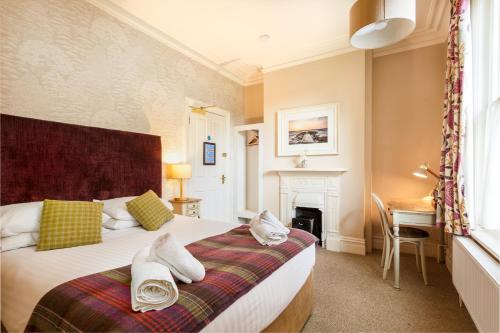 a bedroom with a large bed with a fireplace at Inn in the Park in Bournemouth