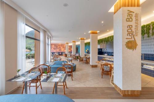 a restaurant with tables and chairs and a bar at Aqua Natura Bay in Porto Moniz