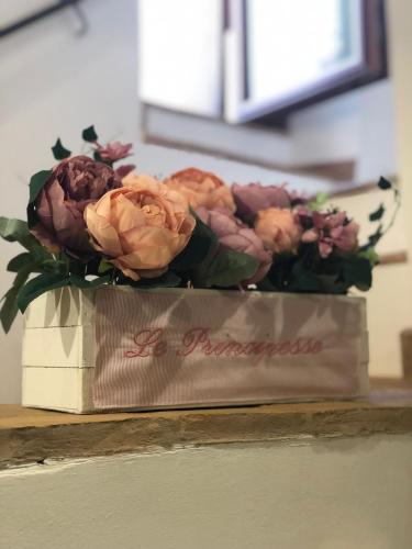 un ramo de flores en una caja sobre una mesa en B&B Le Principesse, en Sermoneta