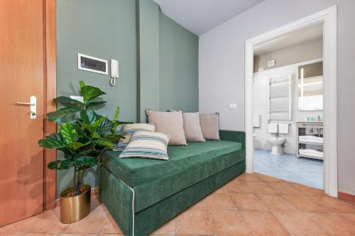 a room with a green couch with pillows on it at Residence Poggio Dei Pini in Marina Romea