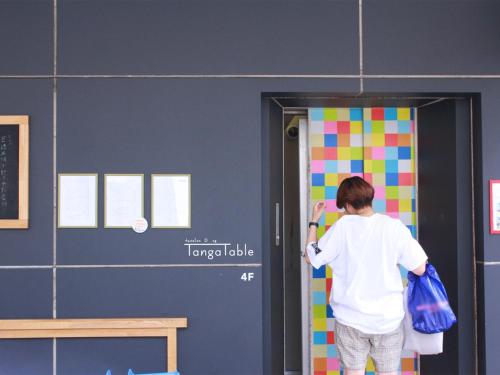 a boy painting a door in a classroom at Hostel TangaTable in Kitakyushu