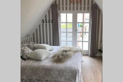 een slaapkamer met een bed met een deken en kussens bij ***** Penthouselejlighed med havudsigt. in Kerteminde