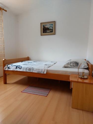 Cama en habitación con suelo de madera en Apartman Nardi, en Vir