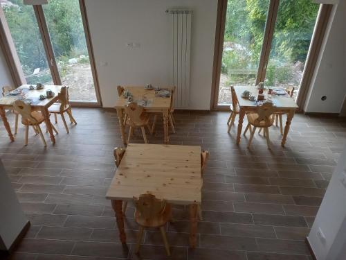 uma sala de jantar com mesas e cadeiras e janelas grandes em Un Passo Dal Cielo em Collebrincioni