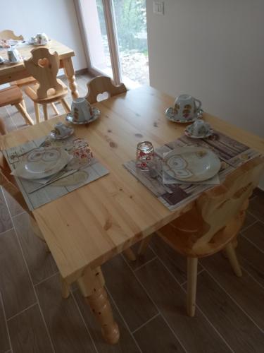 una mesa de madera con platos y platos. en Un Passo Dal Cielo en Collebrincioni