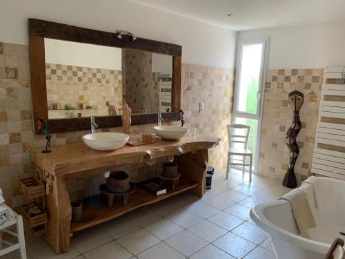 a bathroom with two sinks and a large mirror at "L'Ancienne Etable" Dordogne in Saint-Avit-Saint-Nazaire