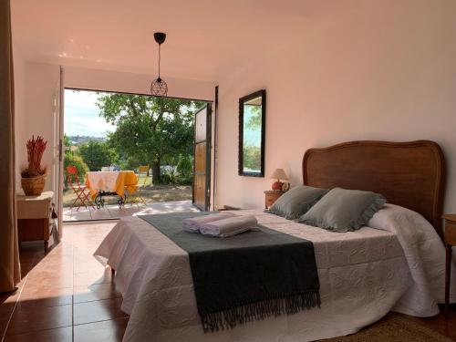 a bedroom with a bed and a sliding glass door at Pabellón en Finca, Villa con Piscina Zarzuela in Villaviciosa de Odón