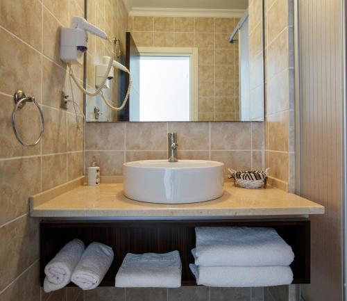 a bathroom with a sink and a mirror and towels at SUENA HOTEL Çeşme in Çeşme