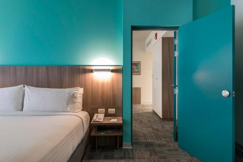 a hotel room with a bed and a blue wall at Holiday Inn - Lima Airport by IHG in Lima