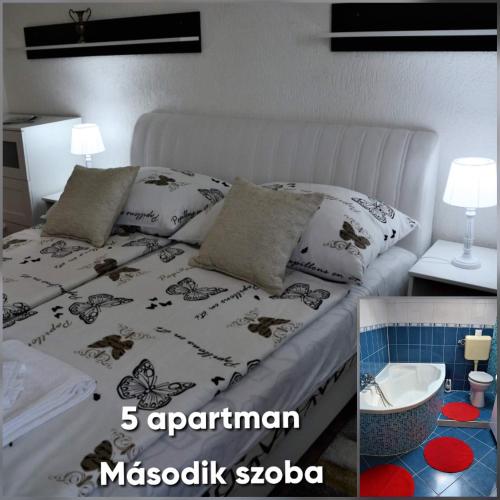 a bedroom with a white bed with pillows on it at Unicum Vendégház in Abádszalók