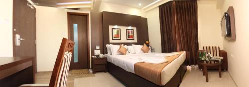 a bedroom with a large bed in a room at Hotel Pristine Residency in Ahmedabad