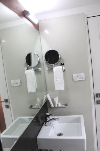 a bathroom with a sink and a mirror at Hotel Pristine Residency in Ahmedabad