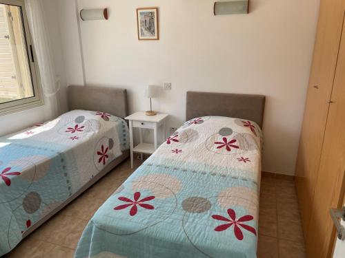 a bedroom with two twin beds and a window at Ilios Akti in Lachi