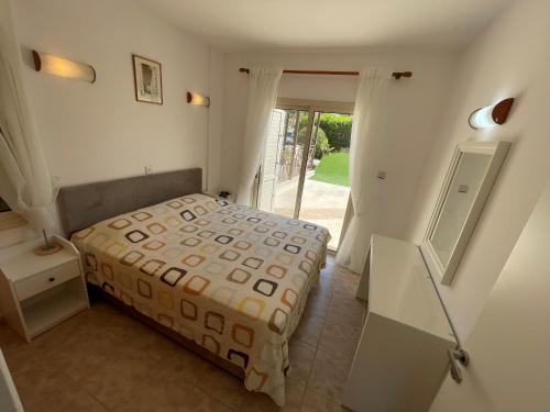 1 dormitorio con 1 cama y puerta a un patio en Ilios Akti, en Lachi