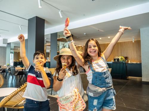two girls and a boy eating ice cream at Kfar Giladi Hotel in Kefar Gil‘adi