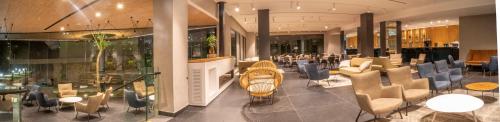 a lobby with chairs and tables in a building at Kfar Giladi Hotel in Kefar Gil‘adi