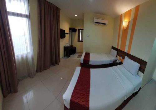 Habitación de hotel con 2 camas y ventana en Sun Inns D'mind 3 Seri Kembangan, en Seri Kembangan