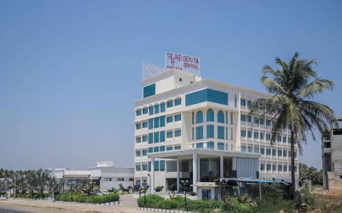 a white building with a sign on top of it at Regenta Central Somnath, Bhalpara in Somnath