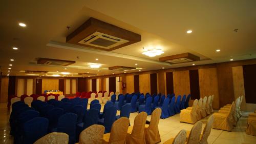 a large room with blue chairs in a building at Regenta Central Somnath, Bhalpara in Somnath