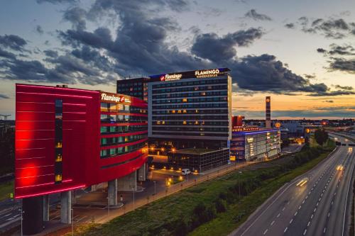 a building with a red facade next to a highway at Break Sokos Hotel Flamingo in Vantaa