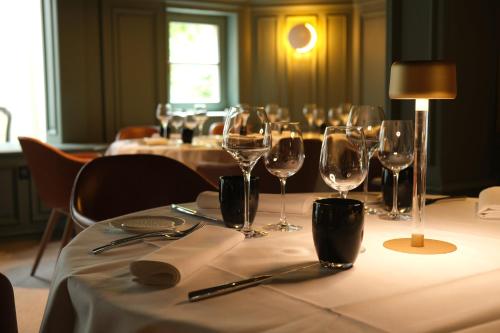 a table with wine glasses and napkins on it at Hôtel Restaurant Relais De La Poste - Strasbourg Nord in La Wantzenau