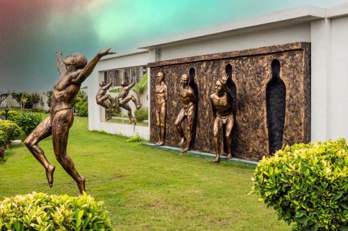 a statue of a group of men on a wall at Regenta Central Somnath, Bhalpara in Somnath