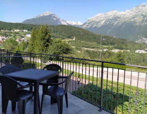a table and chairs on a balcony with mountains at Appartamenti Il Cerbiatto in Cavedago