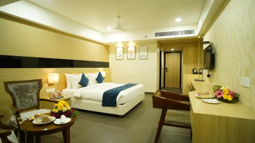 a hotel room with a bed and a desk at Regenta Central Somnath, Bhalpara in Somnath