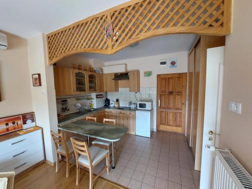 a kitchen with a table and chairs in it at Cserke Napfény Apartman in Cserkeszőlő