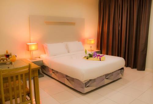 1 dormitorio con 1 cama, escritorio y 2 lámparas en Song Service Apartment formerly known as Jinhold Service Apartment en Kuching