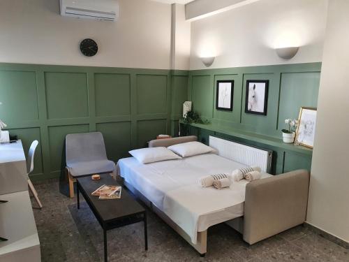 a bedroom with a white bed and a chair at GREEN HOUSE in Karditsa